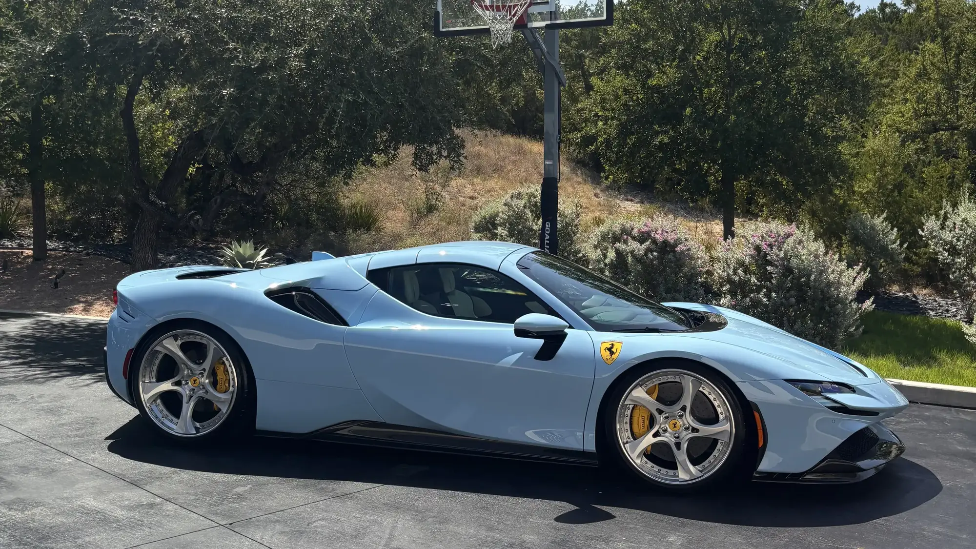 Light blue Ferrari SF90 on a Hill Country driveway